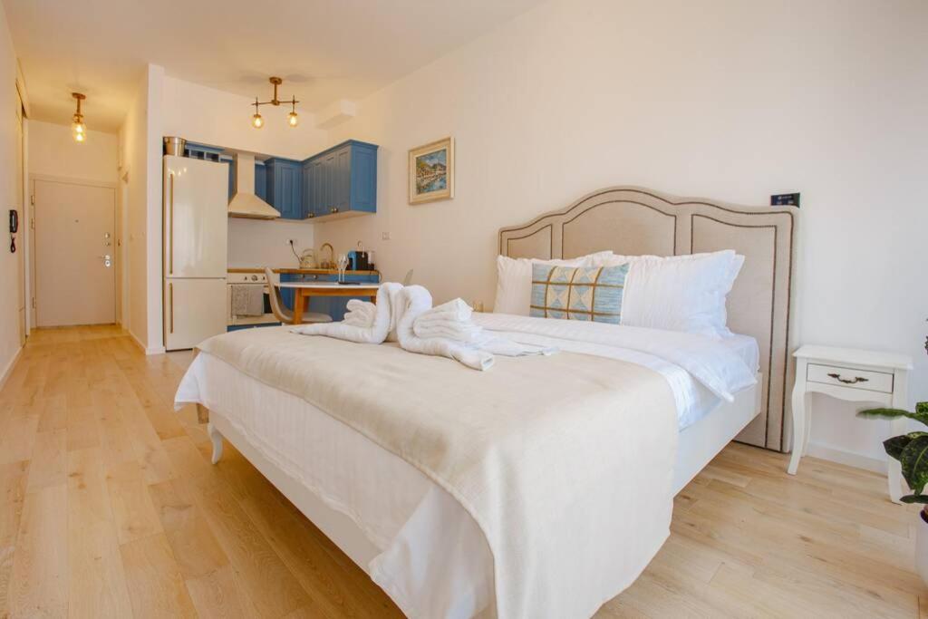 a bedroom with a large white bed with towels on it at Delightful Studio Soho City in Bar
