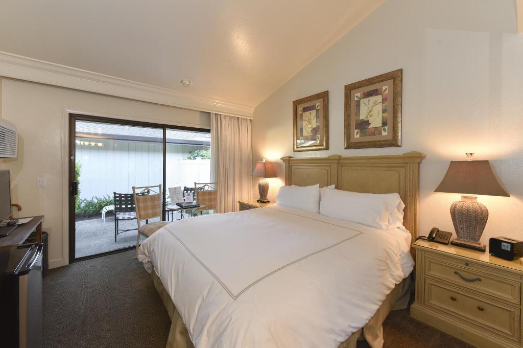 a bedroom with a large white bed and a balcony at 657 Cottages at Silverado residence in Napa