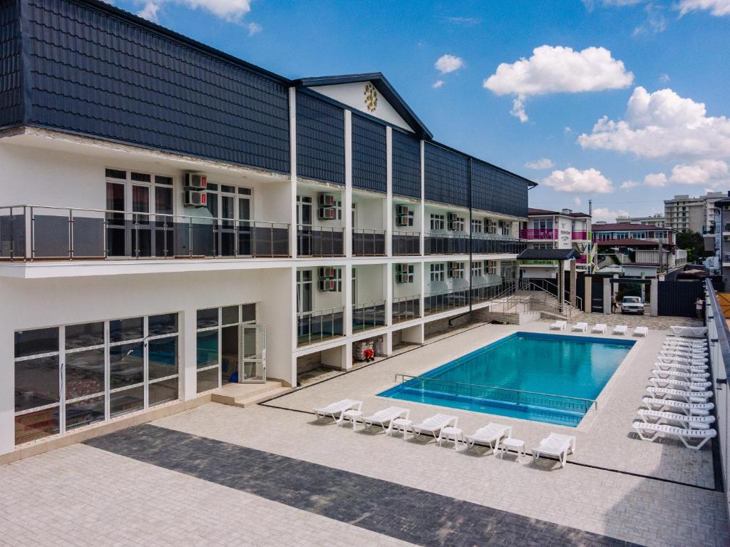 an exterior view of a building with a swimming pool at OneTime Hotel in Anapa