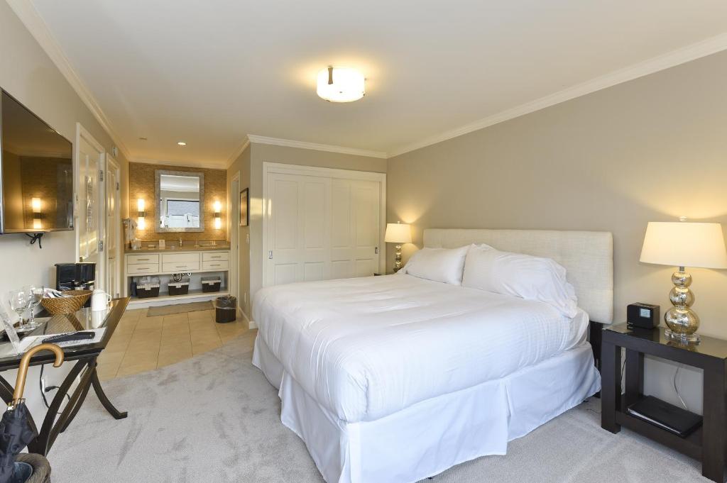 1 dormitorio con 1 cama blanca grande y cocina en 683 Cottages at Silverado residence en Napa