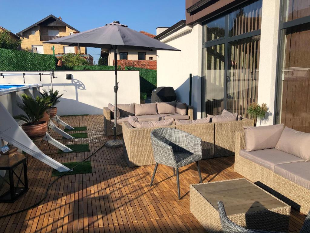 an outdoor patio with furniture and an umbrella at Luxury Apartments 88 in Smederevo