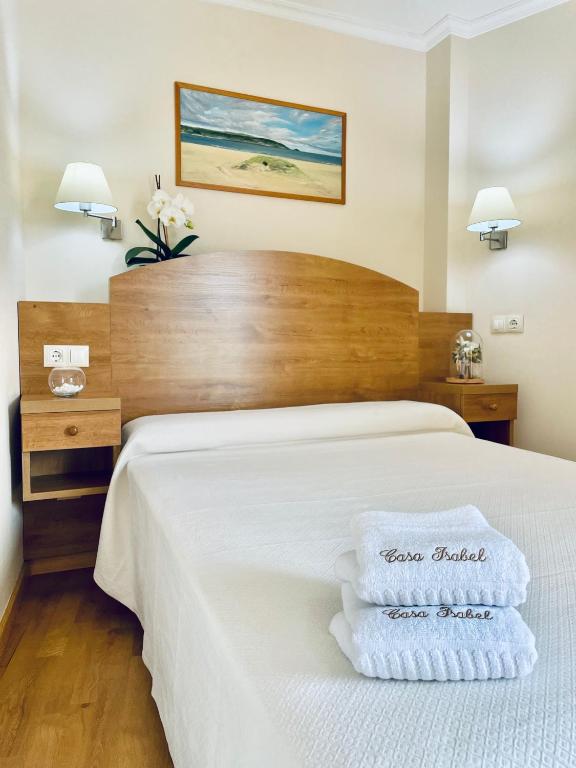 a hotel room with a bed with two towels on it at Hostal Casa Isabel in Portonovo