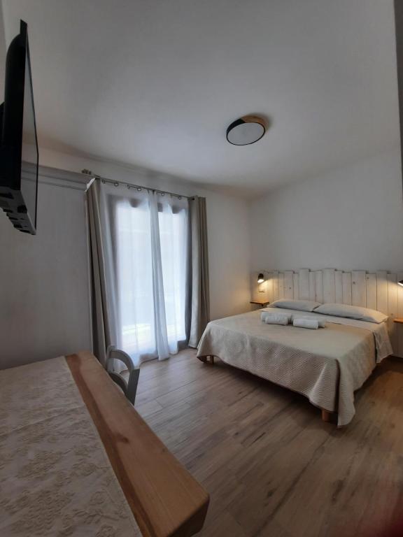 um quarto com 2 camas e piso em madeira em Affittacamere Su Maistu e Linna em Cardedu