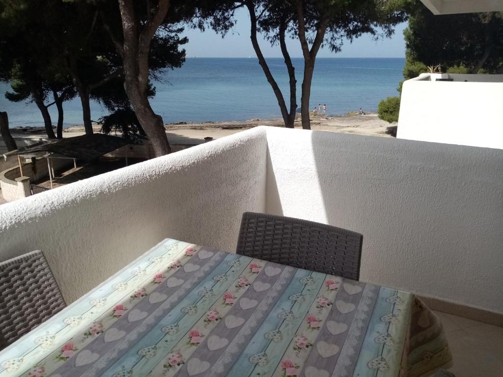 een tafel en stoel met het strand op de achtergrond bij Appartamento La Caletta in Gallipoli