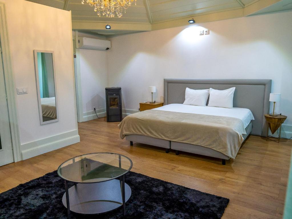 a bedroom with a bed and a glass table at Douro Village in Vila Real
