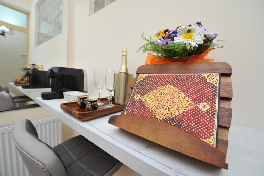eine Theke mit einem Tisch mit einer Blumenvase darauf in der Unterkunft BLISS HOUSE UNIRII in Oradea