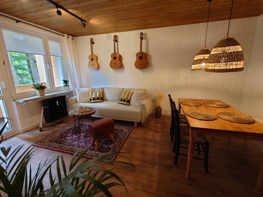 sala de estar con sofá y mesa con guitarras en la pared en ZakoRustic en Zakopane