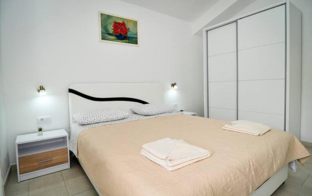 a bedroom with a large bed with two towels on it at Busola Apartments in Tivat