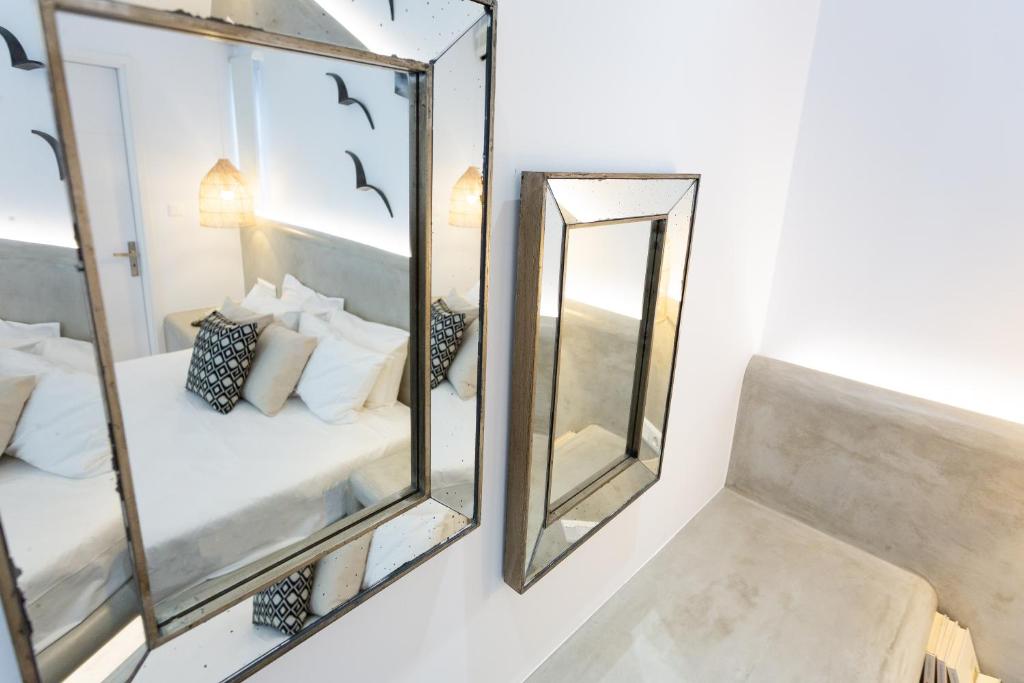 a mirrored room with a bed and a mirror at Likio Studios in Batsi