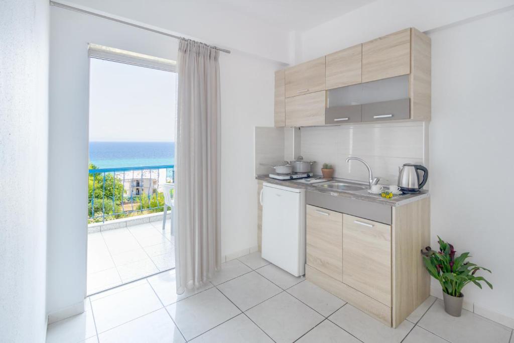 a kitchen with a view of the ocean at Roditsa Patritsia Apartments in Polychrono