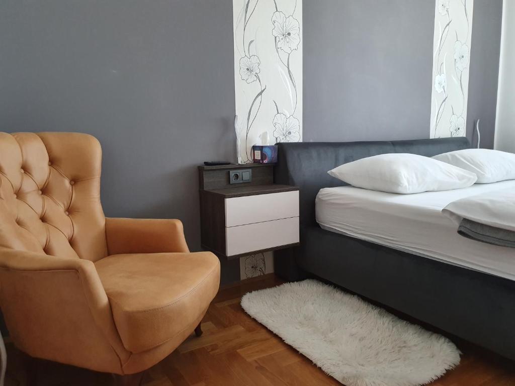 a bedroom with a bed and a chair next to a bed at OSIJEK SPACE CENTAR - Free self check in, Free private parking in Osijek