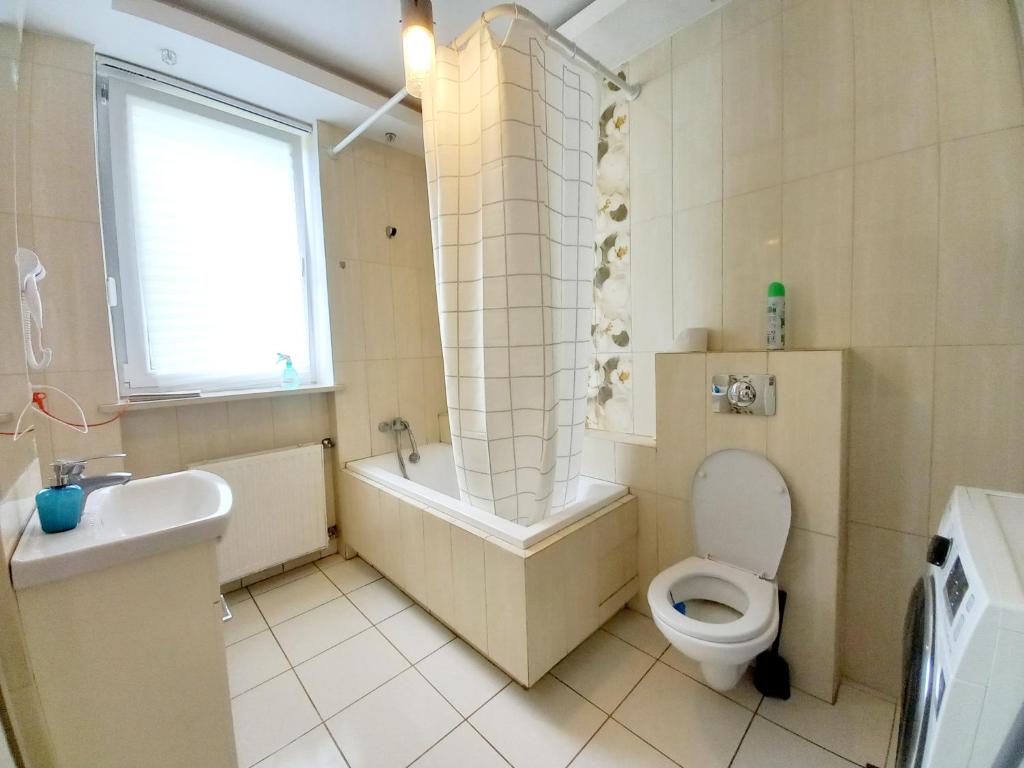 uma casa de banho com uma banheira, um WC e um lavatório. em Pokoje Slawin em Lublin