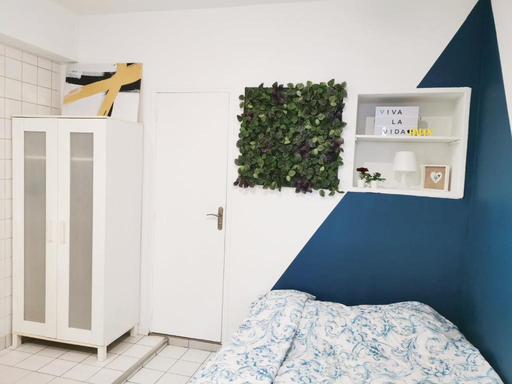 una camera da letto con una porta bianca e una parete blu di Studio à proximité de Paris a Bagnolet