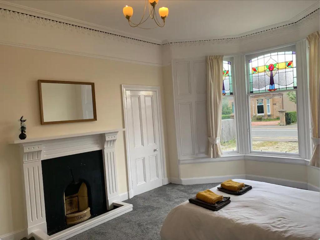 a bedroom with a bed with a fireplace and a mirror at Grangemouth Apartments in Falkirk