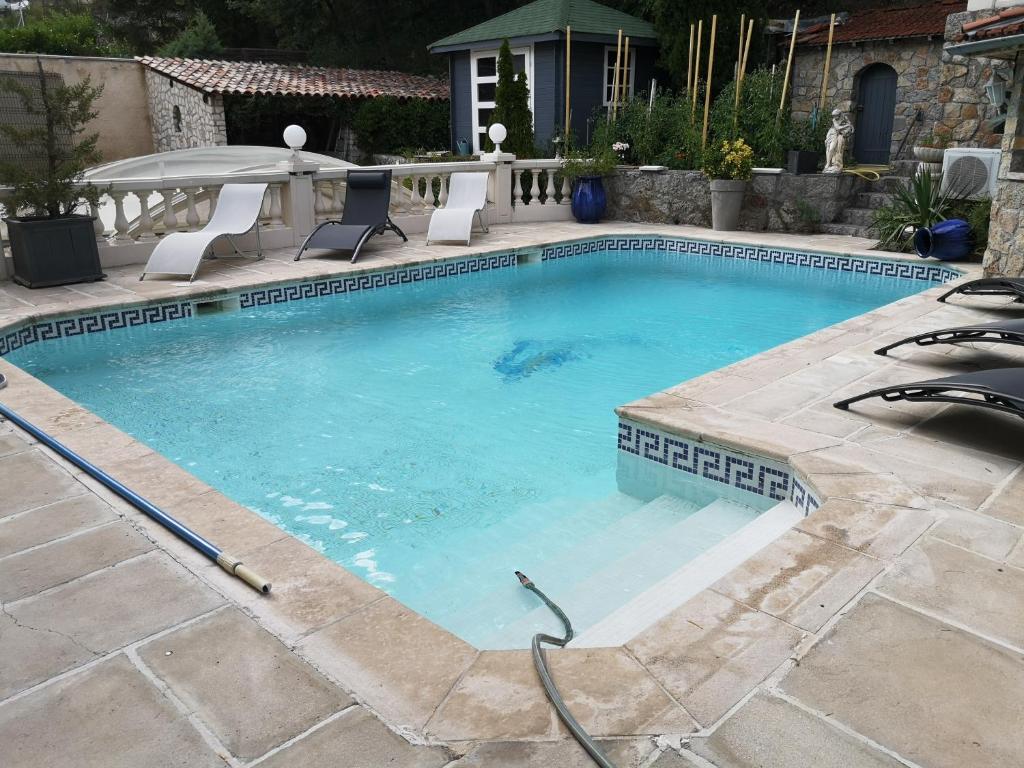 uma piscina com uma mangueira num quintal em Appartement design avec piscine em Digne-Les-Bains