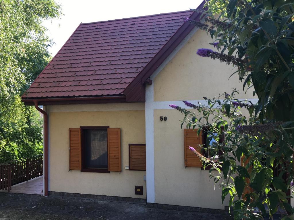 una pequeña casa con techo rojo en Iris Vendégház en Tihany