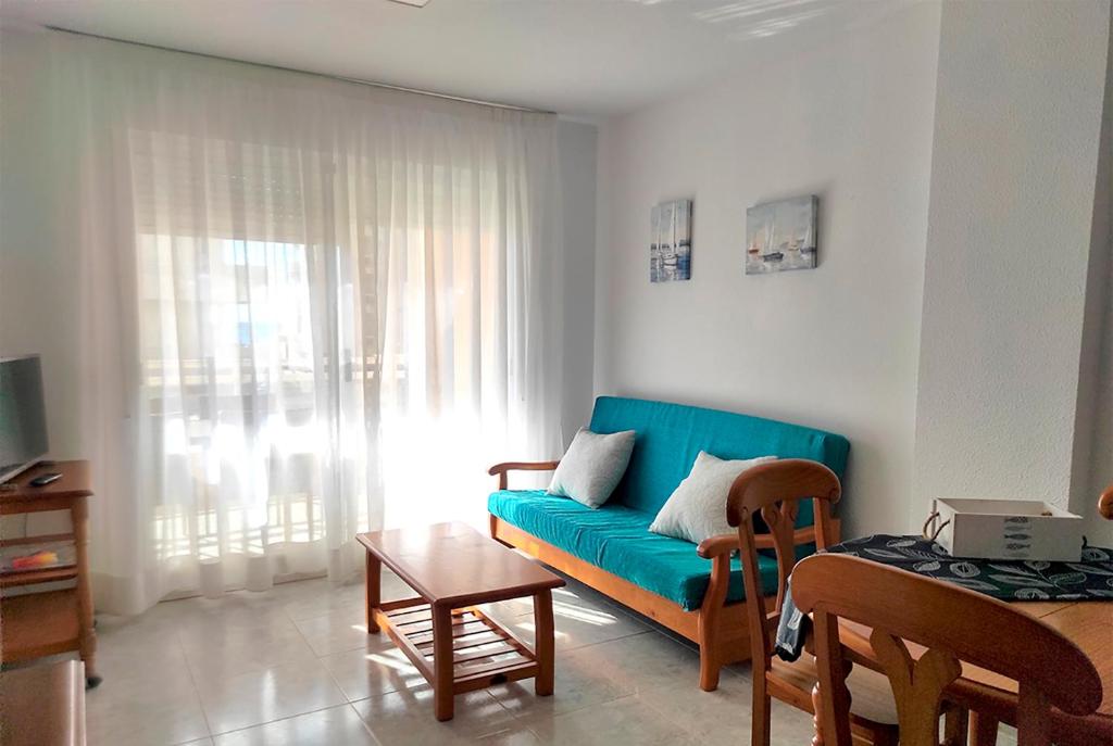 sala de estar con sofá azul y mesa en Apartamento Mar Peñíscola, en Peñíscola