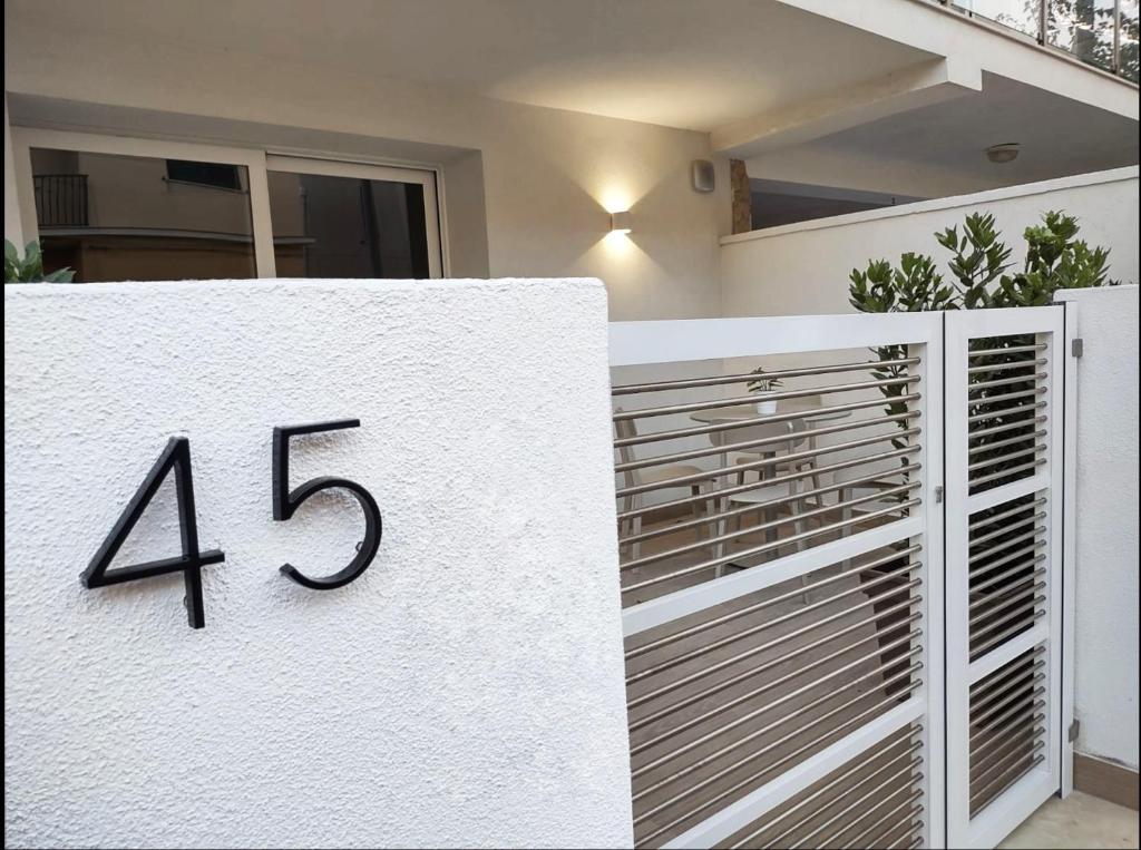 een wit huis met het nummer erop bij Room45 in Marzamemi