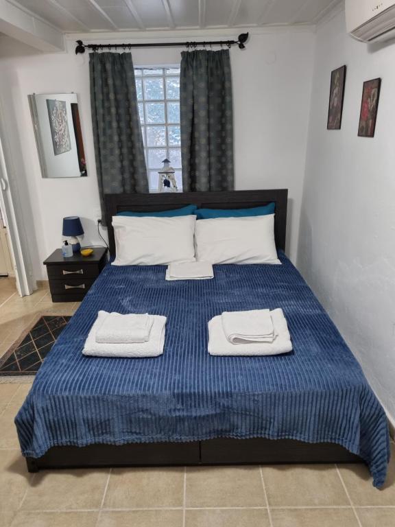 a bedroom with a blue bed with two towels on it at Titika's House in Skiathos Town