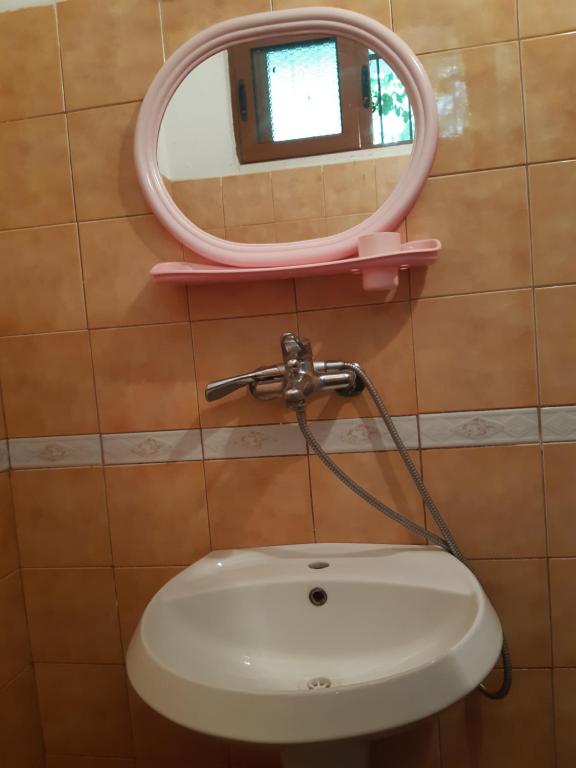 La salle de bains est pourvue d'un miroir rose et d'un lavabo. dans l'établissement H&A Guest House, à Golem