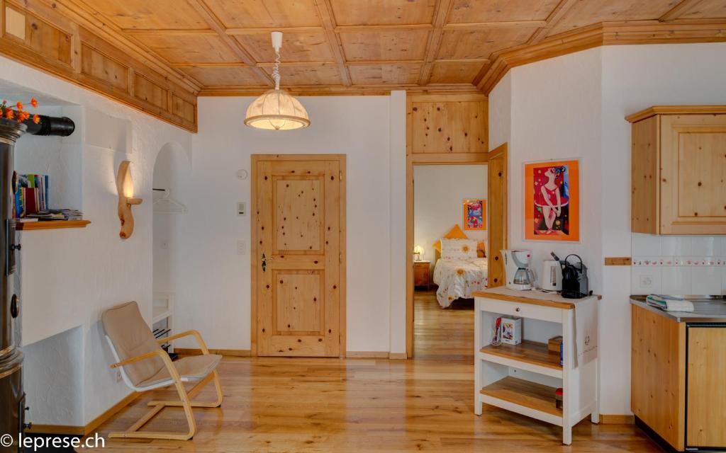 una cucina con soffitti in legno, tavolo e sedie di Casa Zanetti a Poschiavo