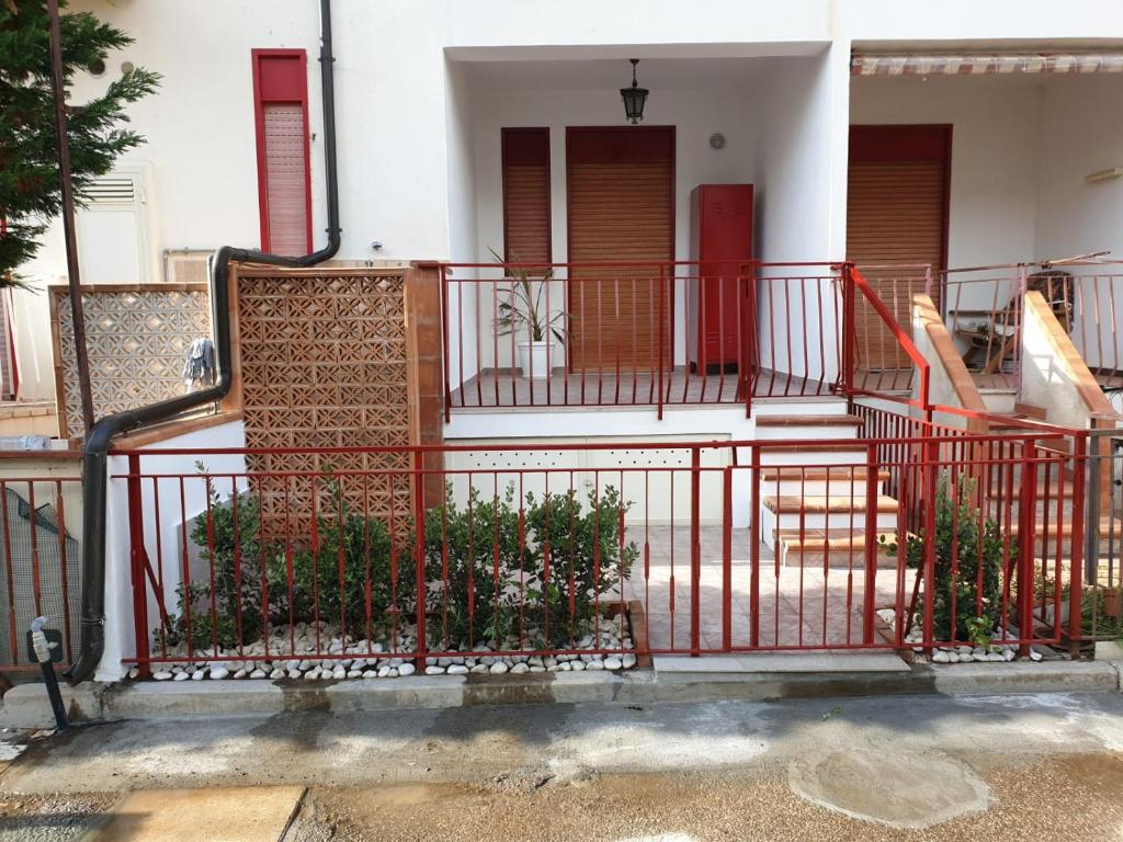 een rood hek voor een huis met trappen bij Casa Lu’ in Mongiove