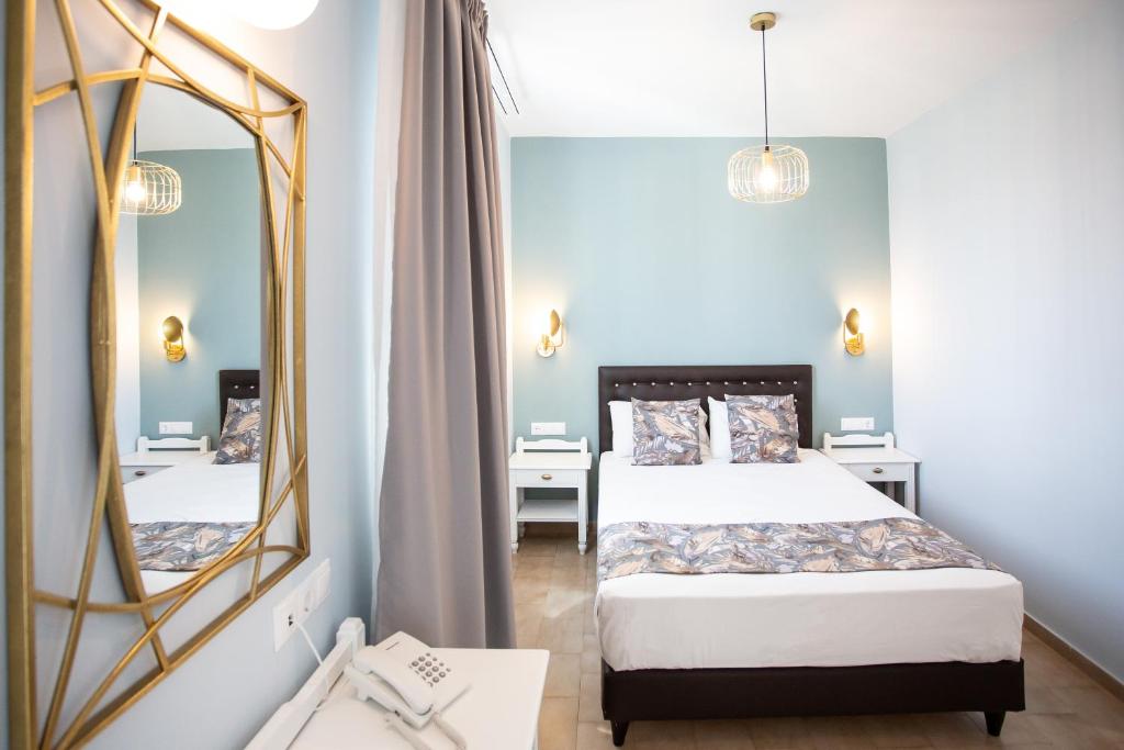 a bedroom with a bed and a large mirror at Likio Studios in Batsi