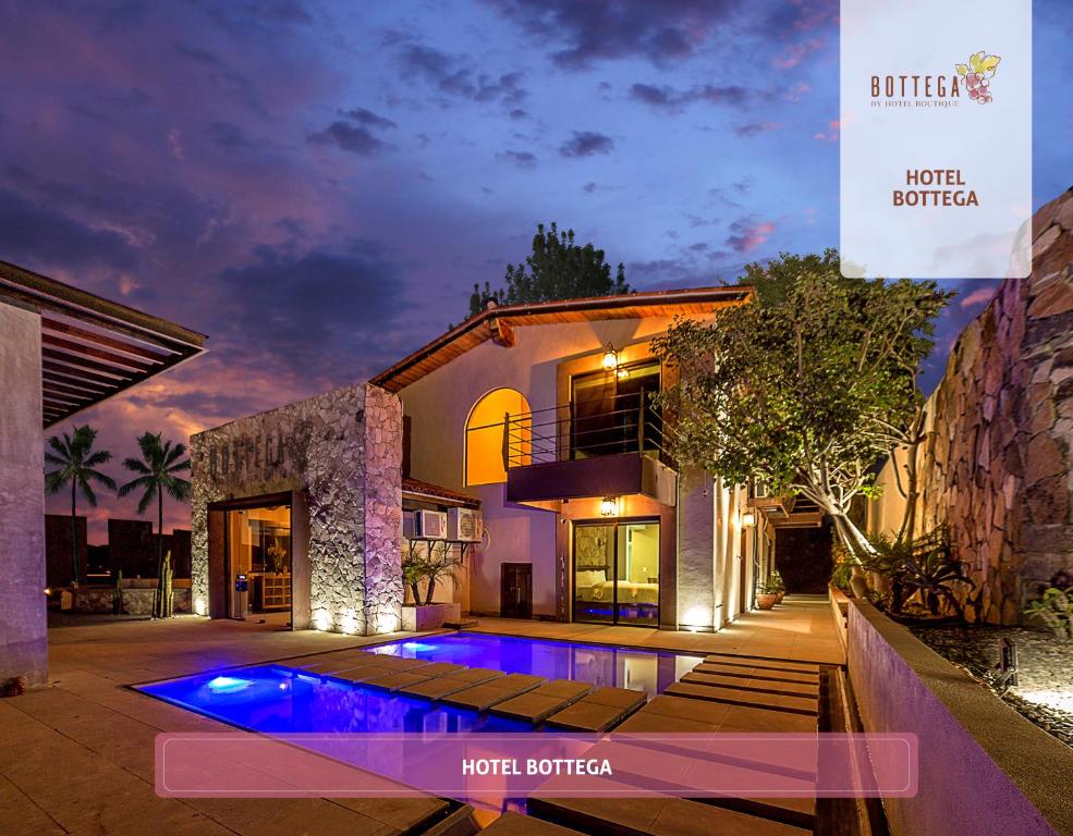 une maison avec une piscine la nuit dans l'établissement Bottega Hotel Boutique, à Valle de Guadalupe