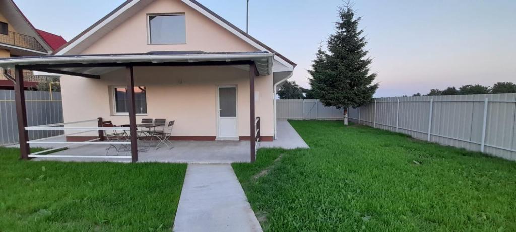 a house with a patio with a table and a fence at Casă de vacanță in Izvoare