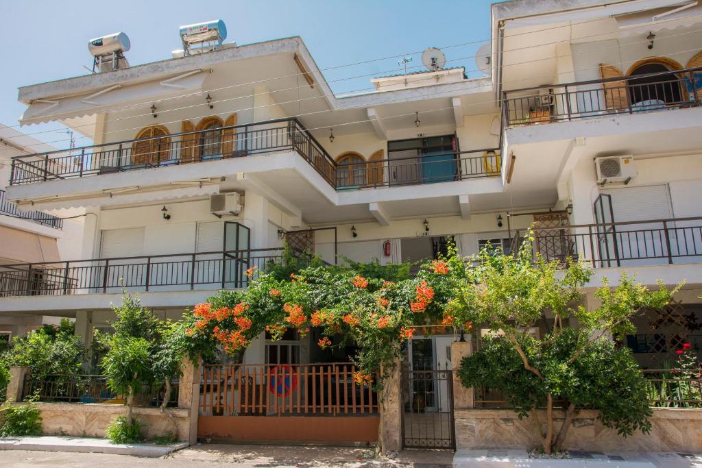 un edificio de apartamentos con flores naranjas delante de él en Apartments Tania, en Paralia Dionisiou