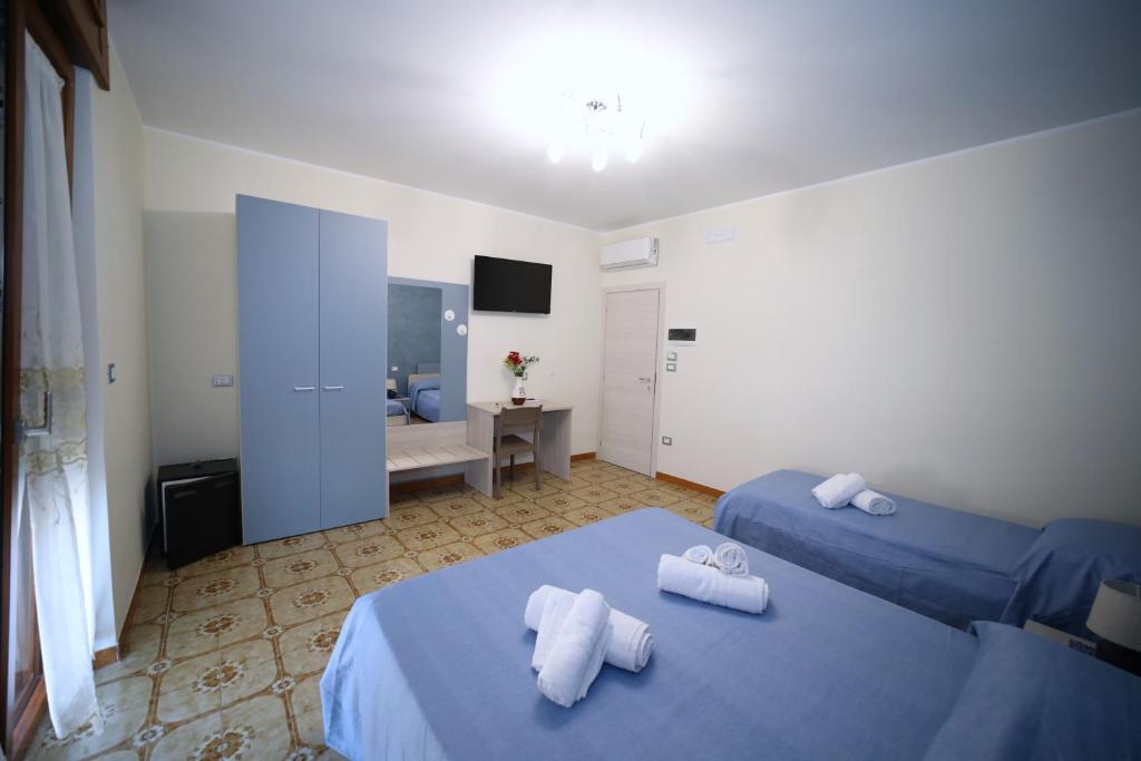 pokój hotelowy z dwoma łóżkami i telewizorem w obiekcie B&B Le Gorgonie w mieście Tortora
