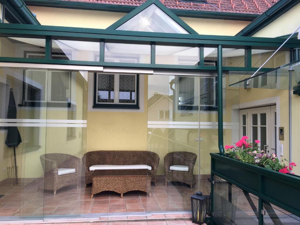 una veranda riparata con sedie e tavolo di Ferienappartement Regina a Schrems
