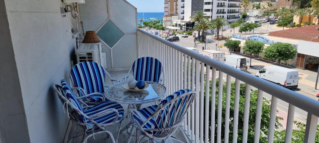 stół i krzesła na balkonie z widokiem na ulicę w obiekcie Apartamento Habana w mieście Benidorm