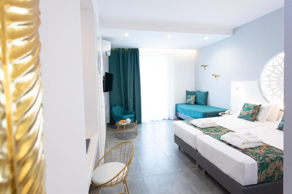 a hotel room with two beds and a blue couch at Likio Studios in Batsi