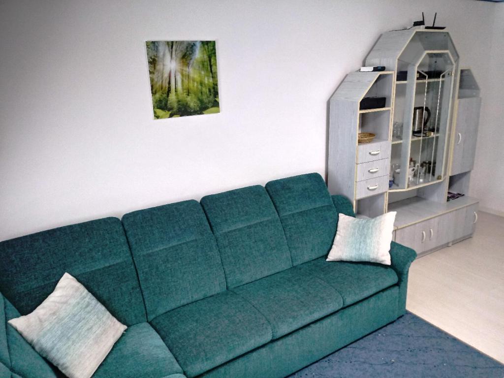 a living room with a green couch and a dresser at Beti Blu, Kaninska vas in Bovec