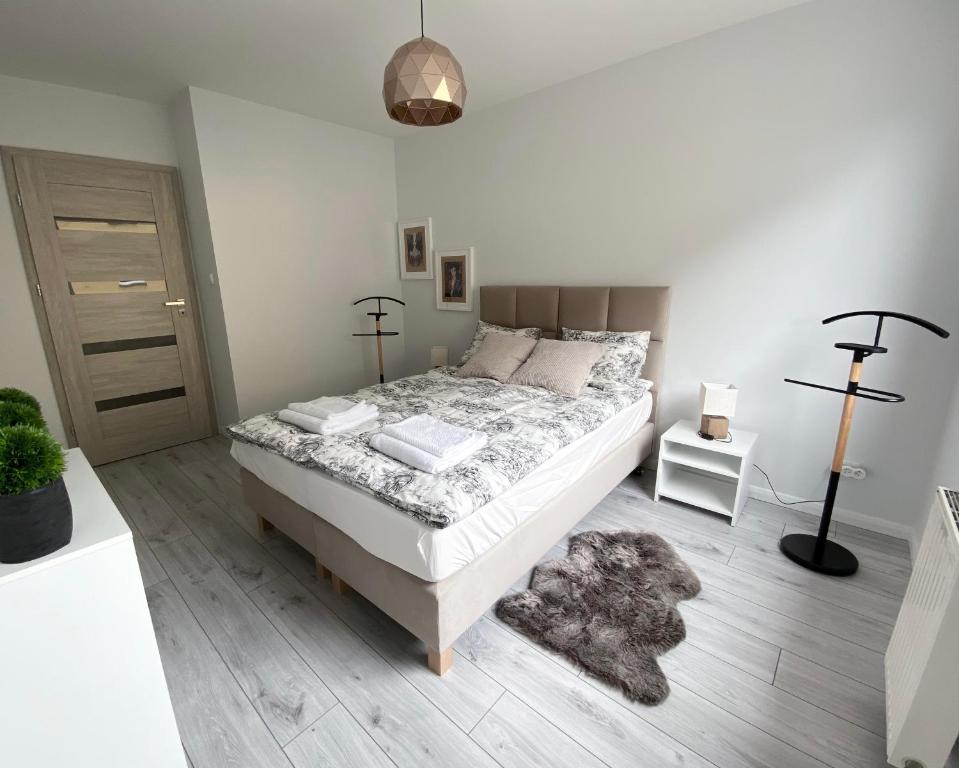 a bedroom with a large bed and a rug at Kosmo Apartament in Wrocław