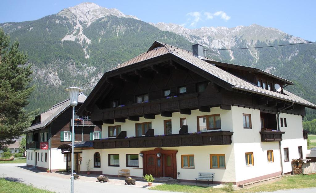 ein großes Gebäude mit Bergen im Hintergrund in der Unterkunft Pension Marienhof in Hermagor