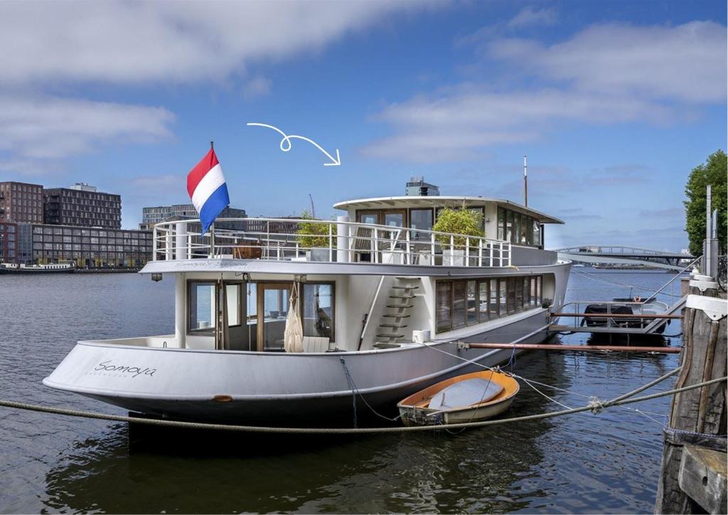 um barco na água com uma bandeira sobre ele em Stunning boat with a view em Amsterdã