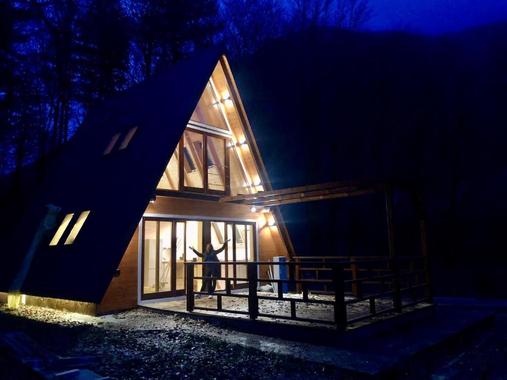 a person standing outside of a house at night at Zen House in Brod na Kupi