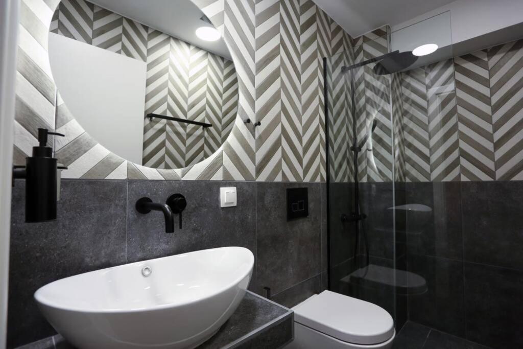 łazienka z umywalką, toaletą i lustrem w obiekcie Valory #1 Aesthetic Stay w Salonikach