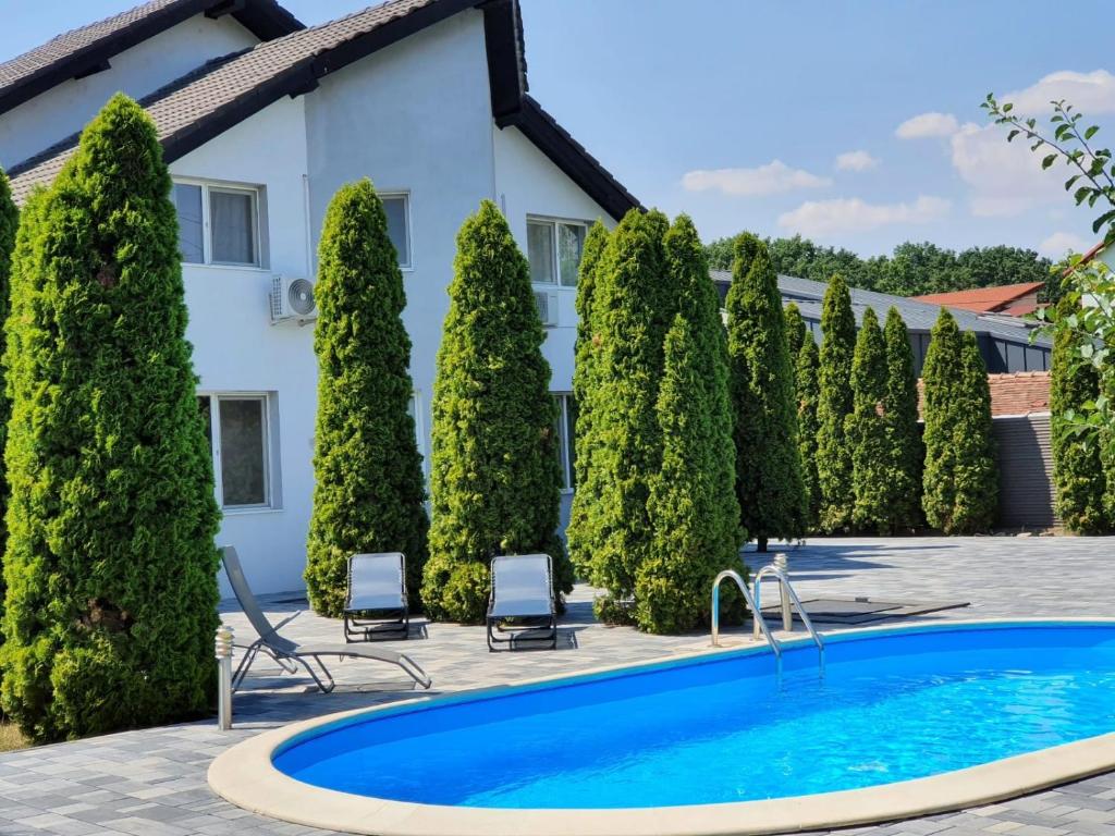una piscina frente a una casa con árboles en GreenWood Residence en Timisoara