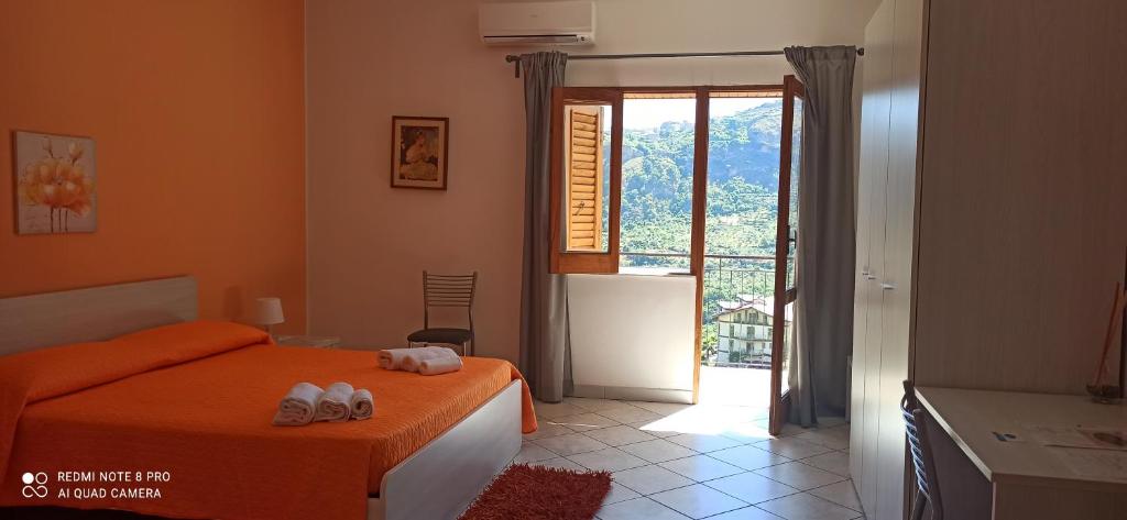 a bedroom with a bed and a door to a balcony at B&B Serena in Longi