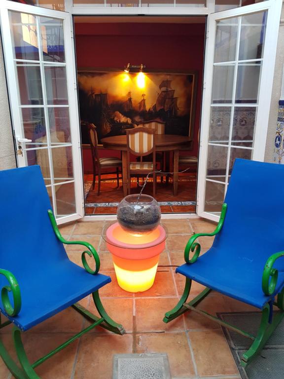 eine Terrasse mit zwei blauen Stühlen und einem Hydranten in der Unterkunft CASALINDA in Almagro