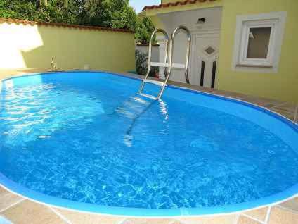a large blue swimming pool in a yard at Apartment in Dramalj 5744 in Dramalj