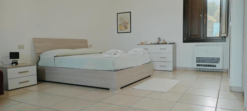 sypialnia z łóżkiem i komodą w obiekcie Sa Teria Village - Camere Deluxe - w mieście Tertenìa