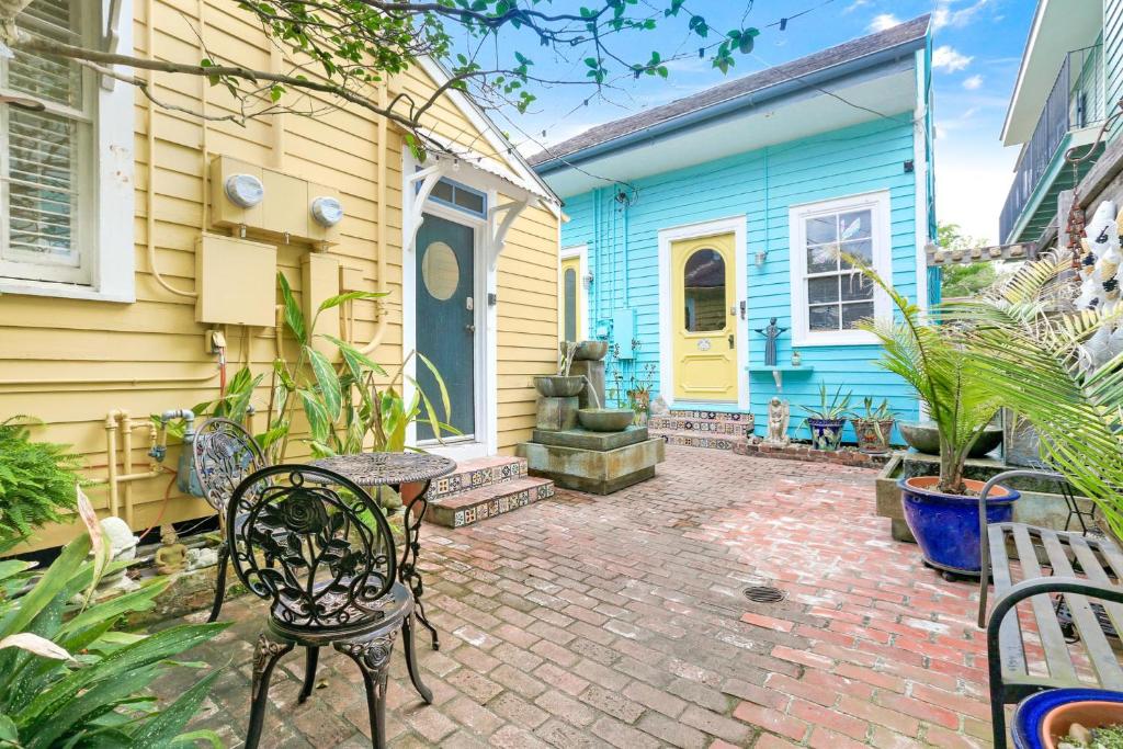 新奥尔良Historic Inn in the Marigny, blocks to French Quarter的房屋前设有带桌椅的天井。