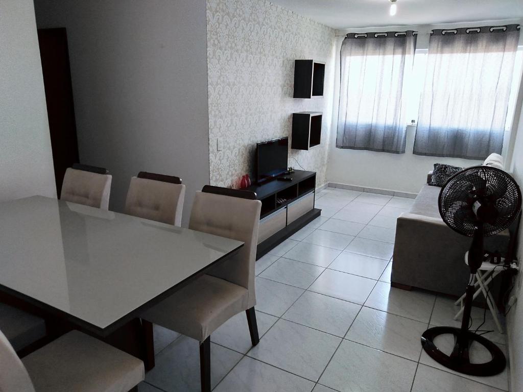 a living room with a table and chairs and a television at Apartamento aconchegante no Jardim Paulistano in Campina Grande