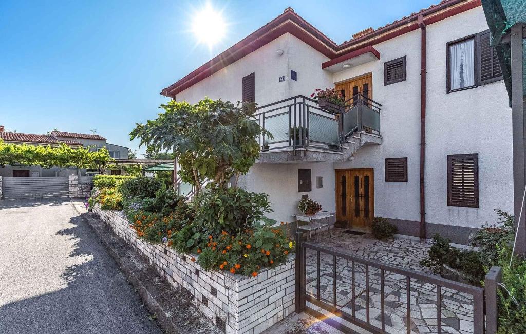 a white house with a balcony and some flowers at Apartment in Porec/Istrien 10190 in Poreč