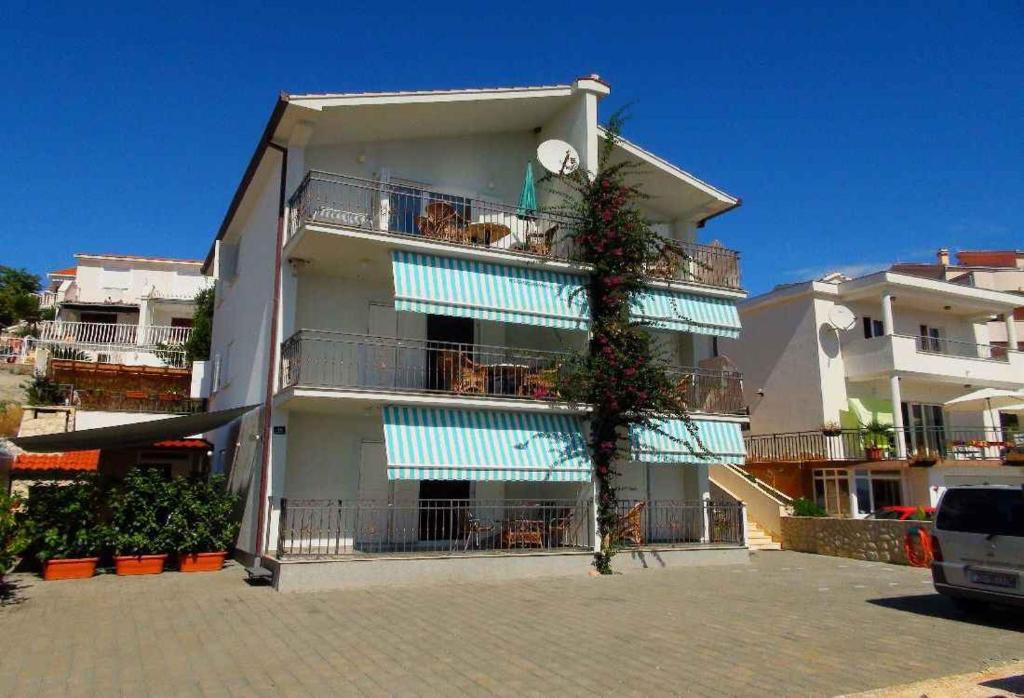 un edificio con balconi bianchi e blu e un albero di Apartment in Okrug Gornji with Two-Bedrooms 2 a Trogir