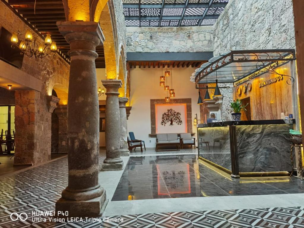 eine Lobby mit einem Tisch und Stühlen in einem Gebäude in der Unterkunft Hotel Don Carlos in Morelia